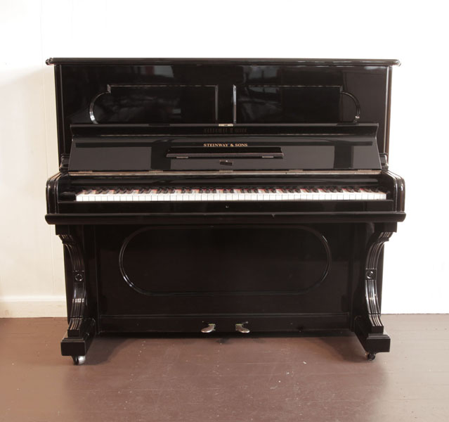 Antique, 1887, Steinway upright piano with a black case and indented front panels. Piano has an eighty-five note keyboard and two pedals.