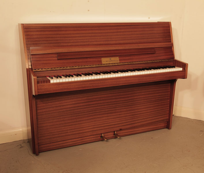 PPre-owned, 1982, Broadwood  upright piano with a polished, mahogany case. Piano has an eighty-eight note keyboard and and two pedals.