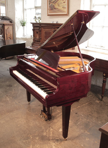 A 1990, Hyundai G-50A baby grand piano with a cherry, mahogany case and brass fittings