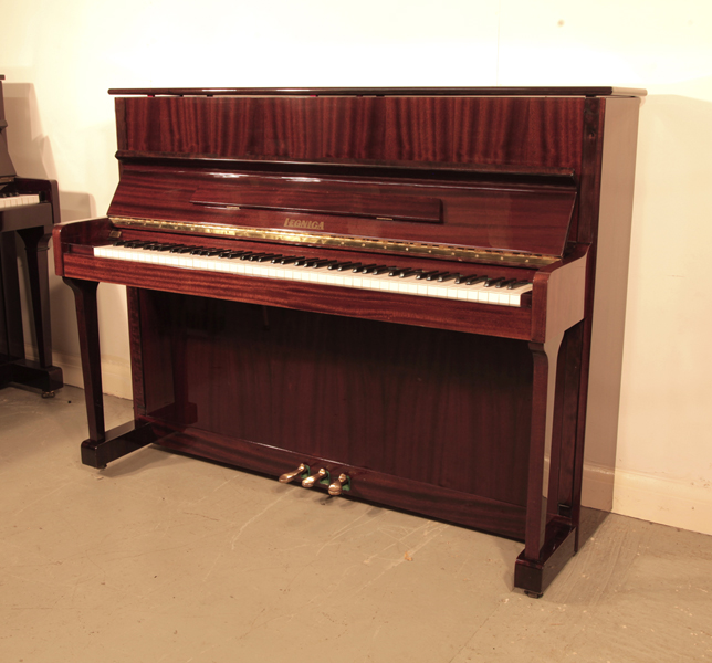  A 1989, Legnica  M110 upright piano with a   mahogany case and brass fittings. Piano has an eighty-eight note keyboard and three pedals