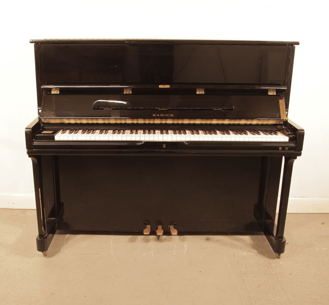 Reconditioned, 1996, Samick SU121SP upright piano with a black case and polyester finish. Piano has an eighty-eight note keyboard and three pedals. 