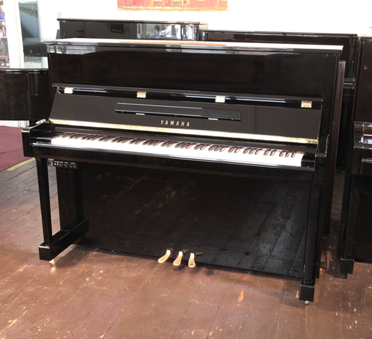 A 2020, Yamaha b3e PE-Silent upright piano with a black case and fitted Silent System. Piano has an eighty-eight note keyboard and three pedals.  